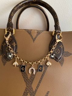 a brown purse with charms hanging from it's handle and on top of it