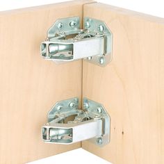 two metal latches are attached to the side of a wooden cabinet door with screws