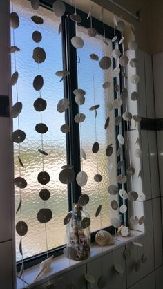 the window is decorated with paper circles and seashells hanging from it's sides