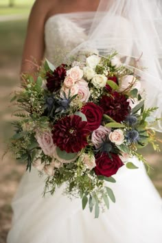 a bridal holding a bouquet of red and white flowers