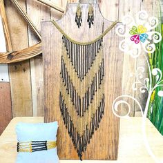 a wooden wall hanging next to a blue pillow on top of a table with decorative items