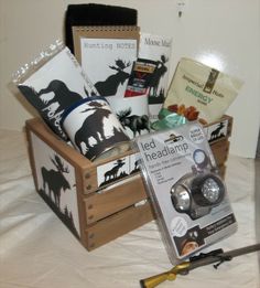 a wooden crate filled with assorted items on top of a bed