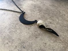 "This unique skull necklace is the perfect witchy gift for that hard to shop for friend, niece, sister or daughter. If you are looking for a one of a kind birthday gift for any lover of oddities, the occult, witchcraft, alchemy, alternative fashion or goth aesthetic... look no further! The little mini skull is hung from a black enameled crescent moon. *In stock and ready to ship from Minnesota in 1-3 days! Crescent Moon Raven Skull Lunar Necklace - Waning Moon Necklace with a 1.5\" (3.81cm) resi Halloween Moon Charm Jewelry As Gift, Unique Black Halloween Necklace, Gothic Moon Charm Necklace As Gift, Gothic Moon Charm Necklace For Gift, Black Skull Necklace For Halloween, Gothic Style Moon Charm Necklace Gift, Gothic Necklace With Moon Charm For Gifts, Gothic Round Pendant Necklace For Halloween, Unique Nickel-free Necklaces For Halloween