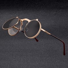 The Quill Steampunk Retro Round Vintage Men's Sunglasses from EFFENTII are the perfect combination of style and functionality. With their ultra-hip steampunk design, these shades will fill you with a sense of nostalgia while still making sure you look stylish as you stay safe in the sun. The unique shape fits every face, while providing excellent coverage for your eyes and blocking out UV Rays. If you are looking for a stylish, retro look that’s perfect for the summer, then look no further!! The Flip Sunglasses, Clothing Ads, Circle Glasses, Flip Up Sunglasses, Steampunk Sunglasses, Vintage Steampunk, Sunglasses Retro, Decoration Photo, Stylish Glasses