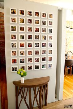 a room with pictures on the wall and a small table in front of it,