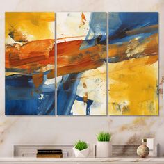 three abstract paintings on a wall in a living room