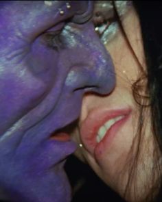 a close up of a person with purple paint on their face