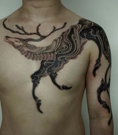 a man with tattoos on his chest is wearing a black and grey dragon tattoo design