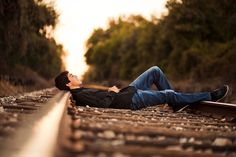 a man laying down on the railroad tracks