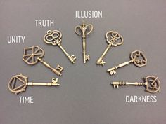 seven antique keys arranged in a circle on a gray surface with one key missing from the middle