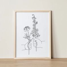 a black and white drawing of two hands holding flowers