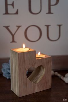 two wooden blocks with candles in the shape of a heart