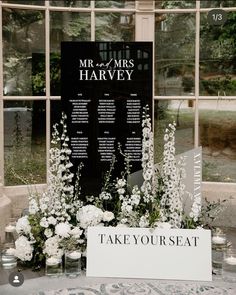 the table is set up with white flowers and seating cards for mr and mrs harvey