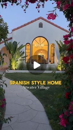 the spanish style home is located in an area that has flowers and greenery around it