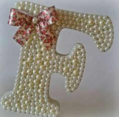 the letter f is decorated with pearls and bows