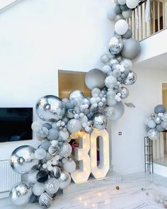 the balloon arch is decorated with silver and white balloons that spell out 10 o'clock