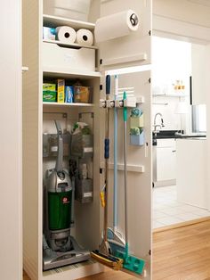 an open cabinet with cleaning supplies in it