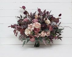 a bouquet of flowers sitting on top of a white wall