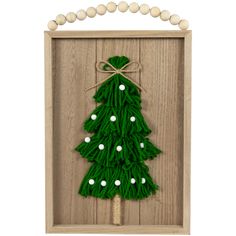 a green christmas tree is in a wooden frame