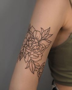 a woman's arm with a flower tattoo on the left side of her arm