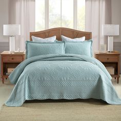 a bed in a bedroom with blue comforter and pillows