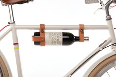 a white bicycle with a leather bottle holder attached to it