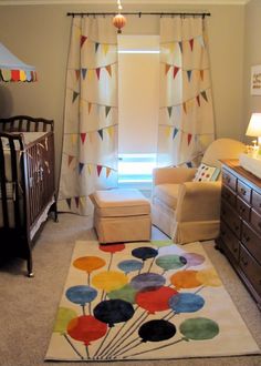 a baby's room with a crib, chair and rug