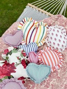 several hearts laid out on top of a bed in the grass next to a hammock