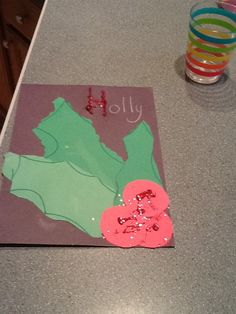 a child's craft is displayed on the counter next to some cups and glasses