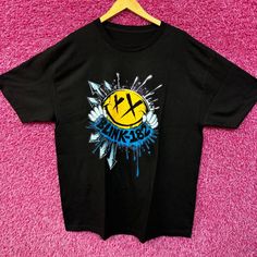 a black t - shirt with a smiley face on the front and an x logo on the back