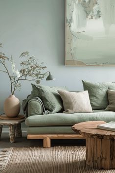 a living room filled with furniture and a painting on the wall above it's coffee table