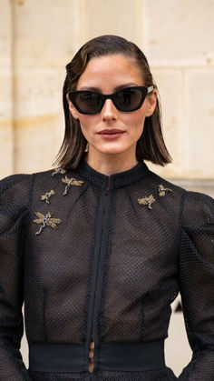 a woman wearing sunglasses and a black dress