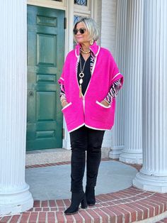 an older woman standing on steps wearing a pink cardigan