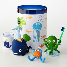 an assortment of bathroom items on a white surface with blue rimmed cup and lid