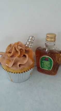 a cupcake next to a bottle of honey