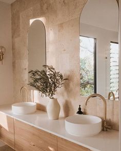 a bathroom with two sinks and mirrors on the wall