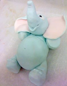 an elephant toy laying on top of a white surface