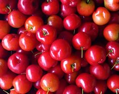 a pile of red cherries sitting on top of each other