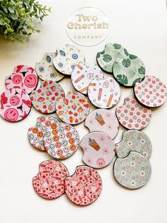 a bunch of buttons sitting on top of a white table next to a potted plant