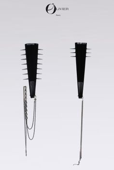 two black hair brushes with chains attached to them