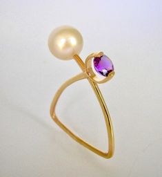 This is an edgy and geometric ring in 14K yellow gold featuring a round 8.9mm freshwater pearl and a round Amethyst. Pearl And Amethyst Ring, Pearl And Amethyst, Geometric Ring, Amethyst Ring, Freshwater Pearls, Jewelry Rings, Pearl Earrings, Amethyst, Yellow Gold