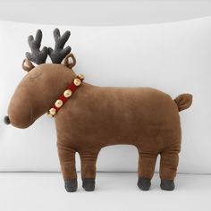 a stuffed reindeer is sitting on a pillow