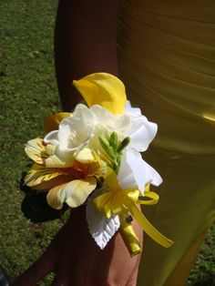 a person holding a bouquet of flowers in their hand on the grass outside with other people nearby