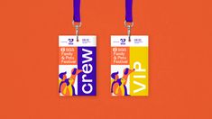 two luggage tags with purple and yellow lanyards attached to them on an orange background