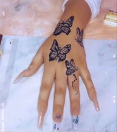 a woman's hand with butterflies painted on it