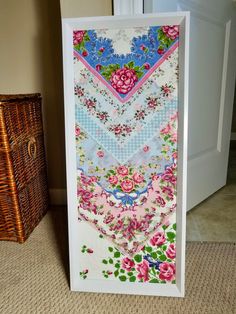 a painting on the ground next to a basket and a white door with pink flowers