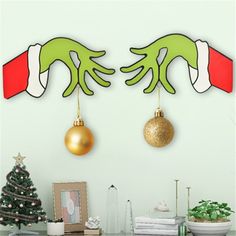 two green hands hanging from the ceiling with christmas decorations