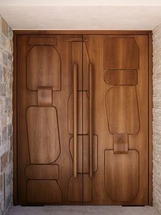 a modern wooden door is shown in front of a brick wall and stone flooring