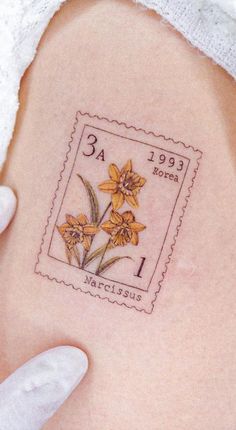 a stamp with some flowers on it in someone's left side arm and hand