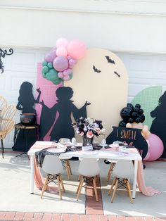 a party table with balloons and decorations on the wall behind it is set up for a halloween party